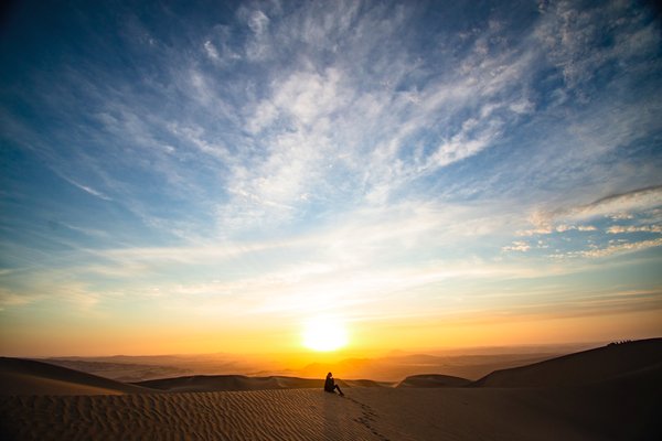 Photo montrant un homme assis seul dans le désert